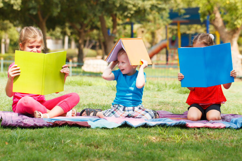 Happy children of three sitting with books